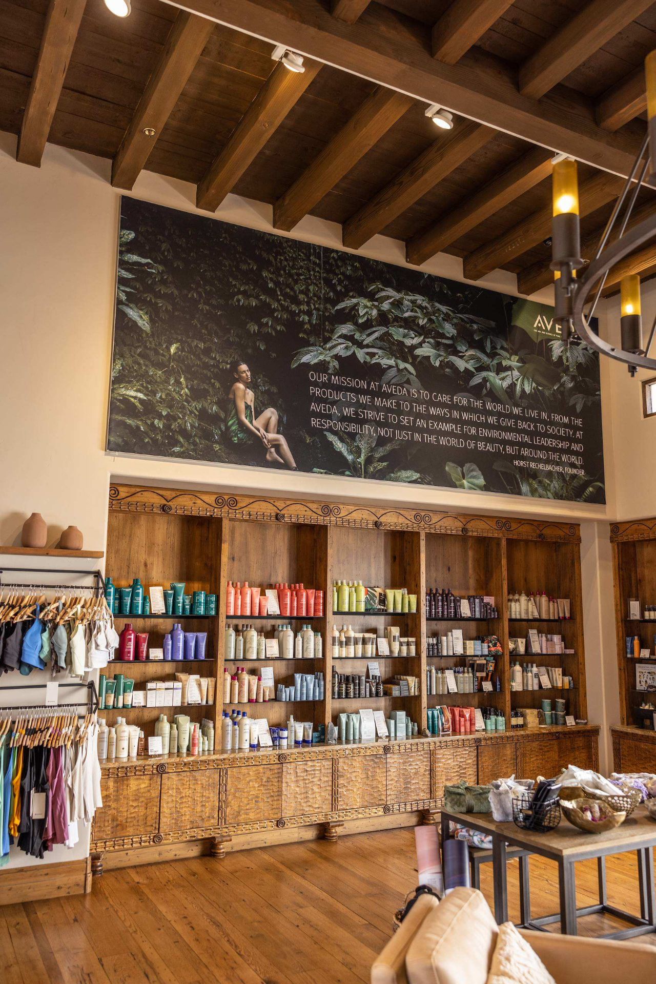Aveda product wall with mission mural and reclaimed wood shelving