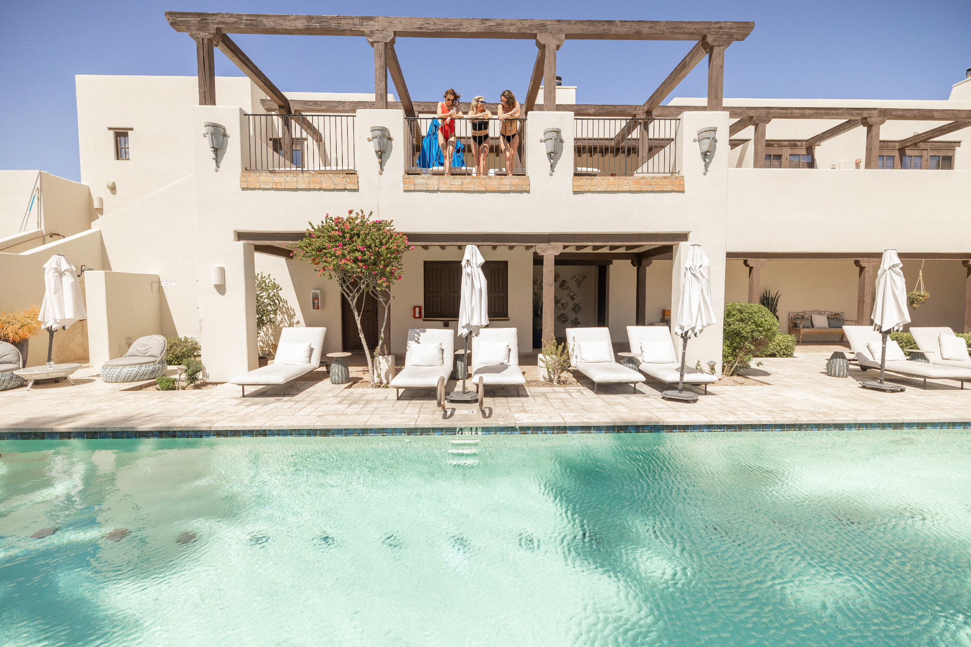 Wigwam Resort pool deck with lounge chairs and resort buildings