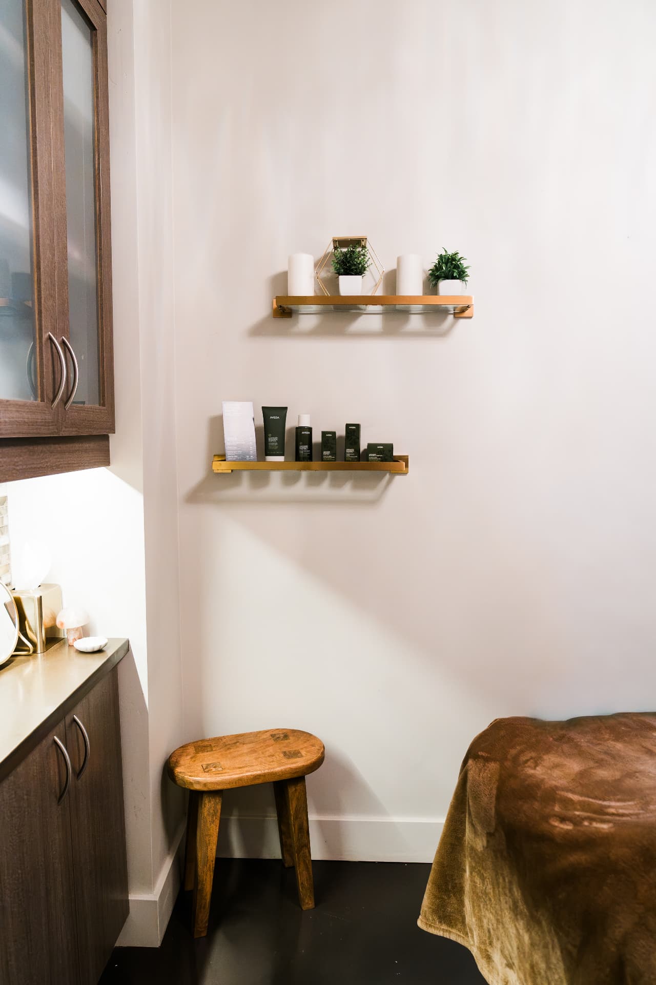 Aveda products displayed on brass shelves in a Scottsdale treatment room