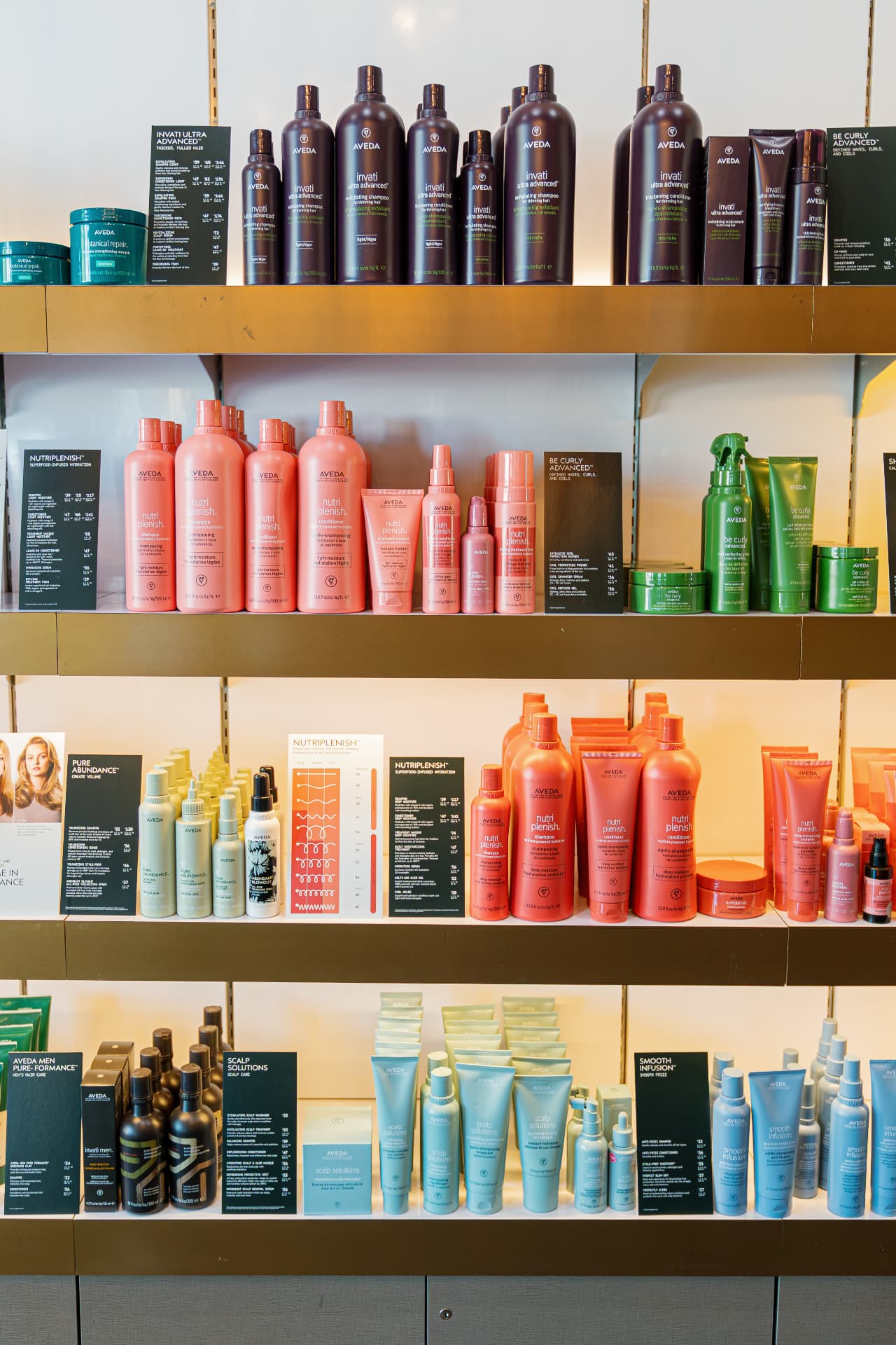 Aveda plant-powered products displayed on wooden shelves