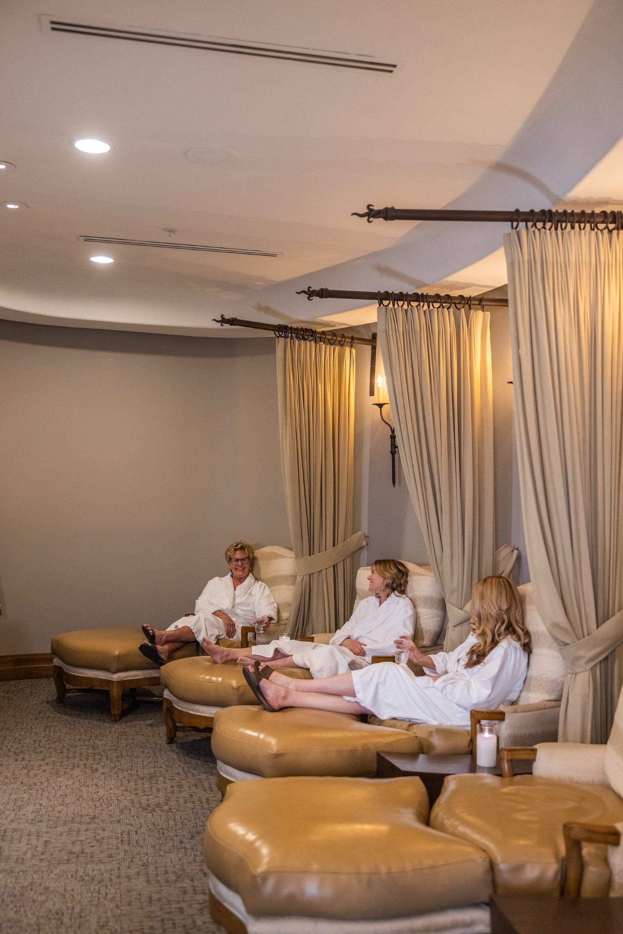 Relaxation lounge with robed guests and draped alcoves