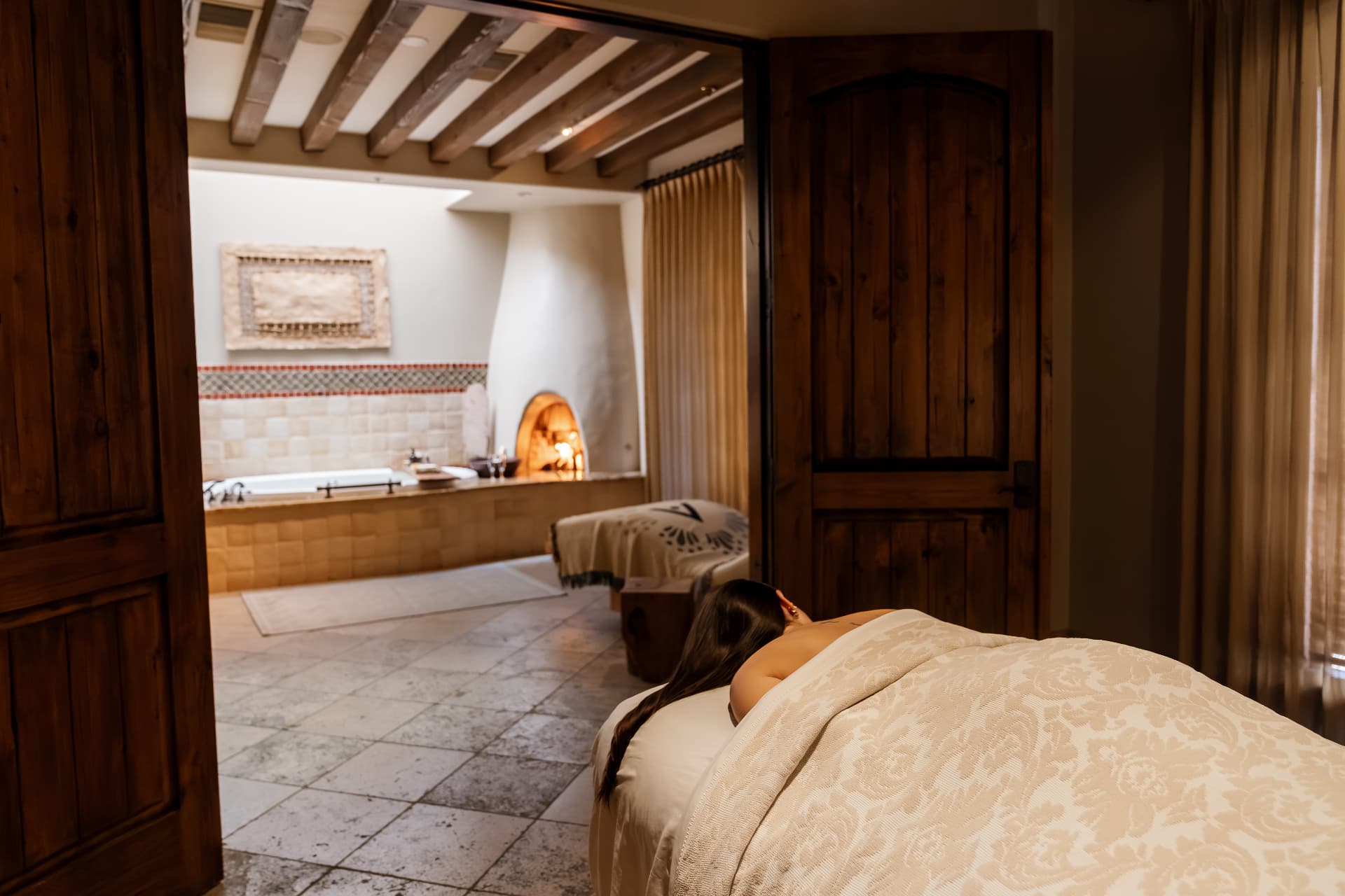 Massage treatment room with soft lighting and draped table