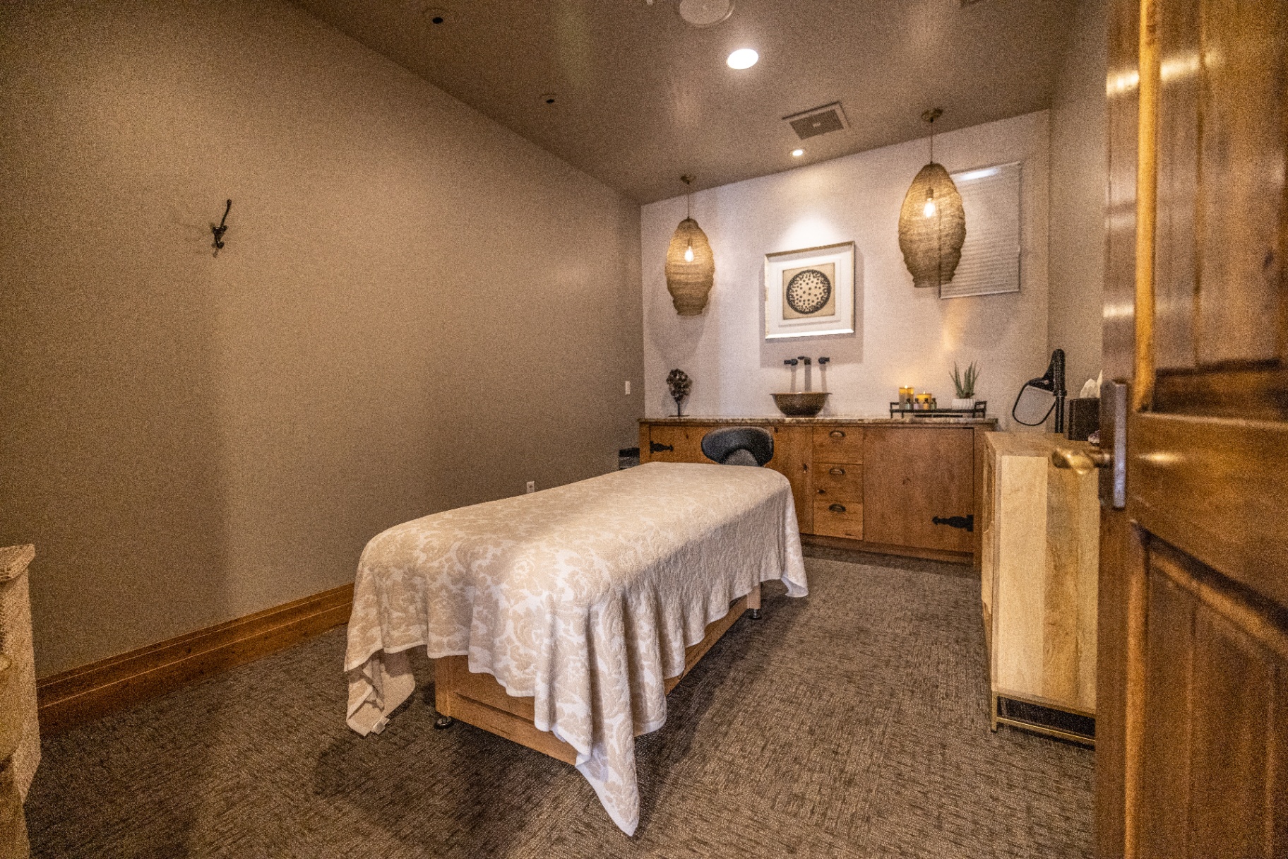 Massage treatment room with soft lighting and draped table