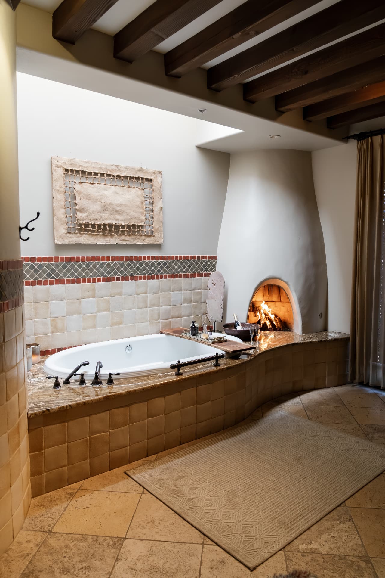 Soaking tub beside a glowing adobe fireplace